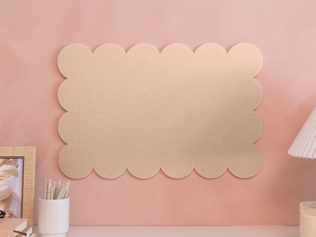 Decorative wall panel with scalloped edges on a pink wall