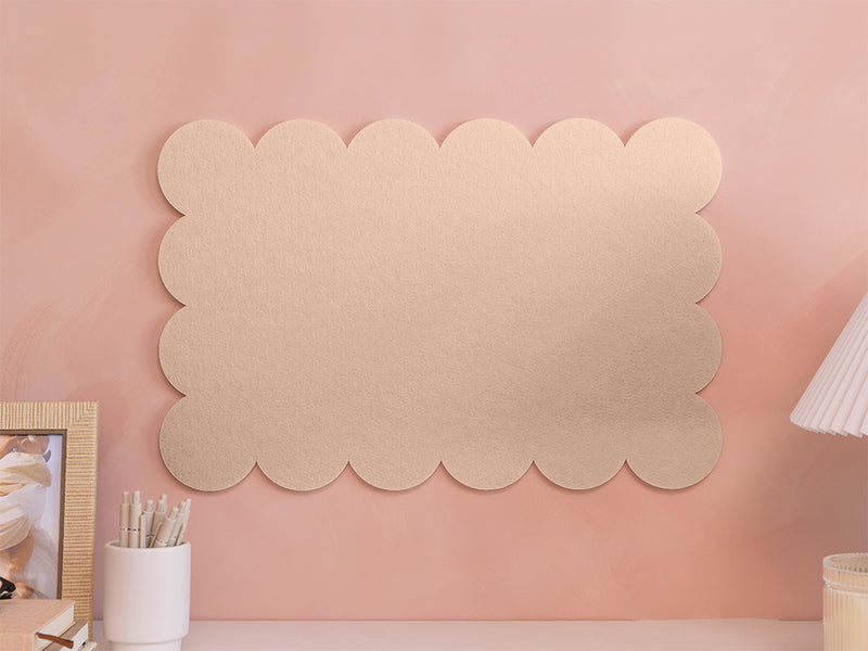 Decorative wall panel with scalloped edges on a pink wall