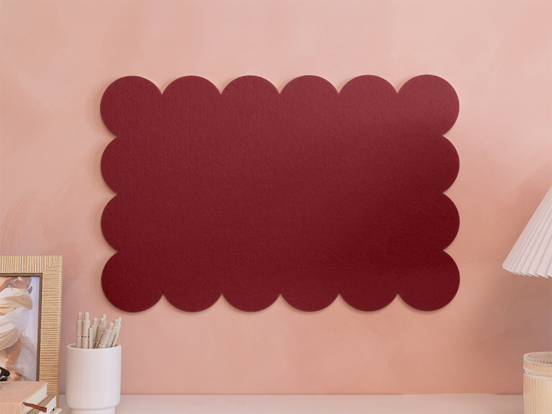 Decorative red wall panel on a pink wall with a lamp and photo frame in the background.