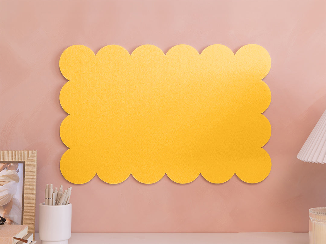 Yellow scalloped acoustic panels on a pink wall