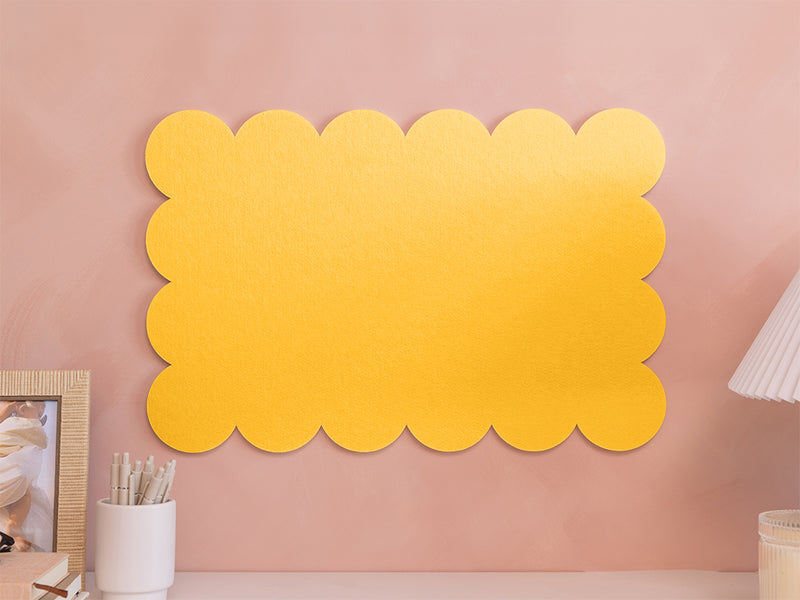 Yellow scalloped acoustic panels on a pink wall