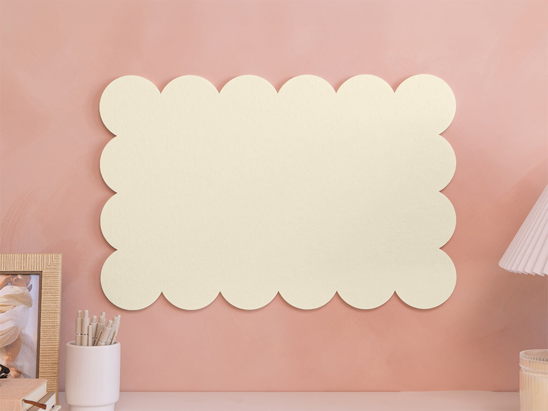 Decorative wall art with cloud shapes on a pink wall
