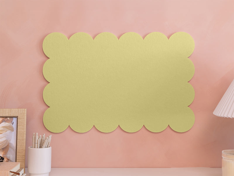 Decorative green wall panel on a pink wall with a lamp and photo frame.