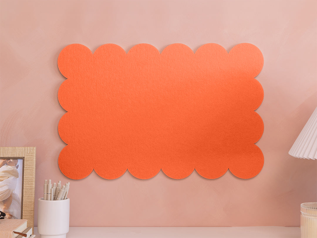 Orange scalloped acoustic panel on a pink wall