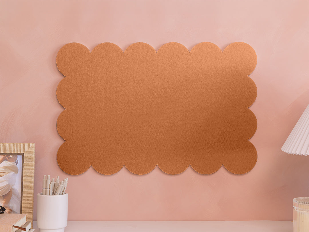 Decorative cork board with scalloped edge on a pink wall
