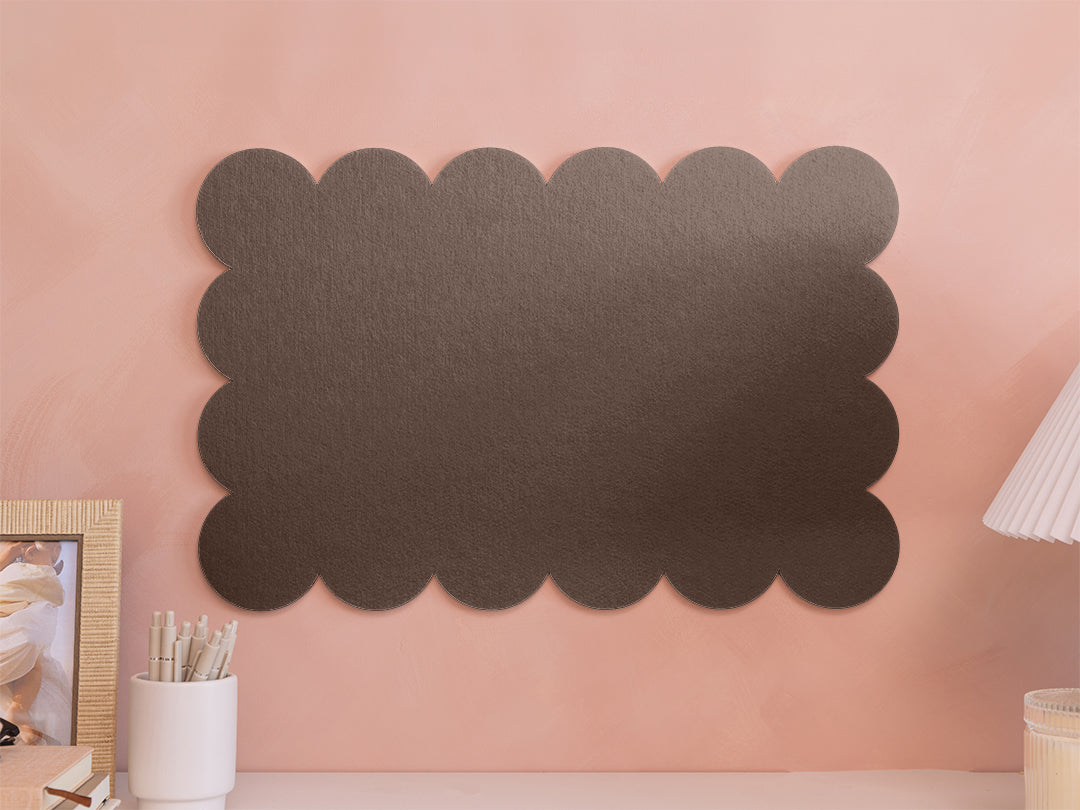 Decorative black cloud-shaped wall art on a pink wall.