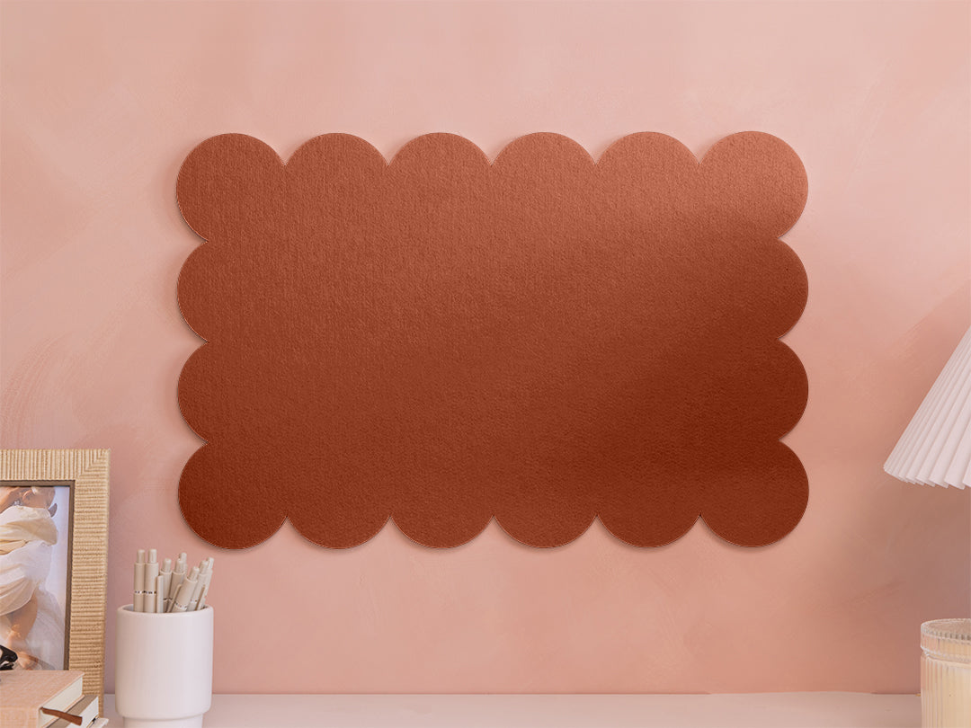 Decorative brown scalloped wall panel on a pink wall with a lamp and picture frame.