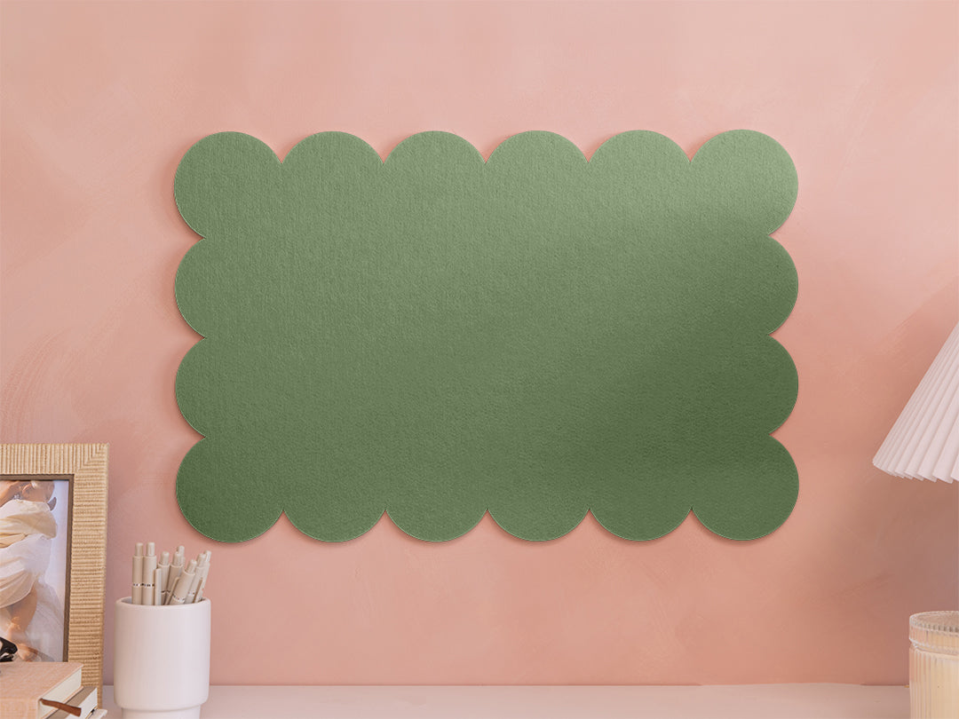 Green scalloped-edge wall panel on a pink wall with decor items.