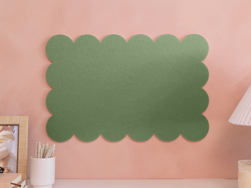 Green scalloped-edge wall panel on a pink wall with decor items.