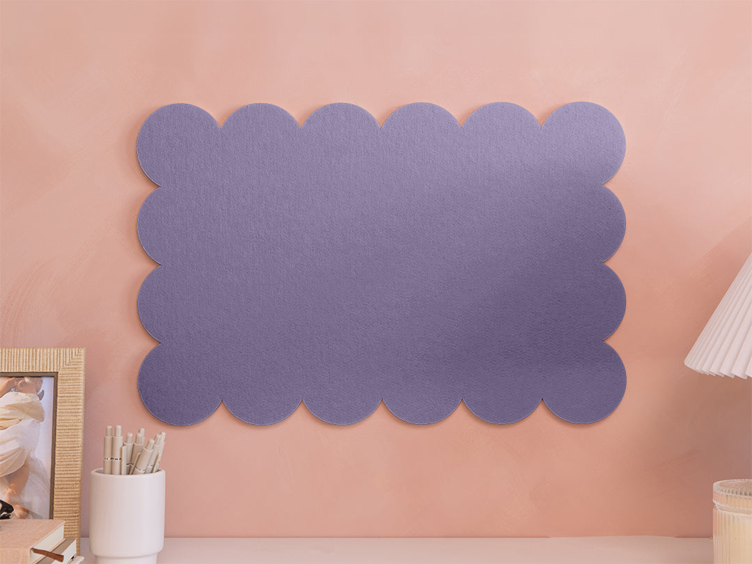Decorative purple scalloped wall art on a peach-colored wall.