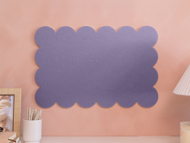 Decorative purple scalloped wall art on a peach-colored wall.