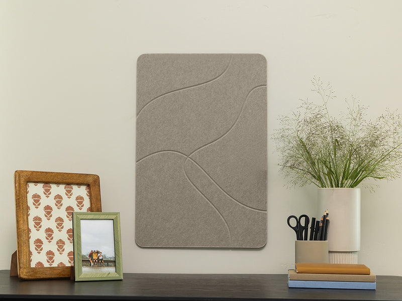 Gray acoustic panel on a wall with decorative items below