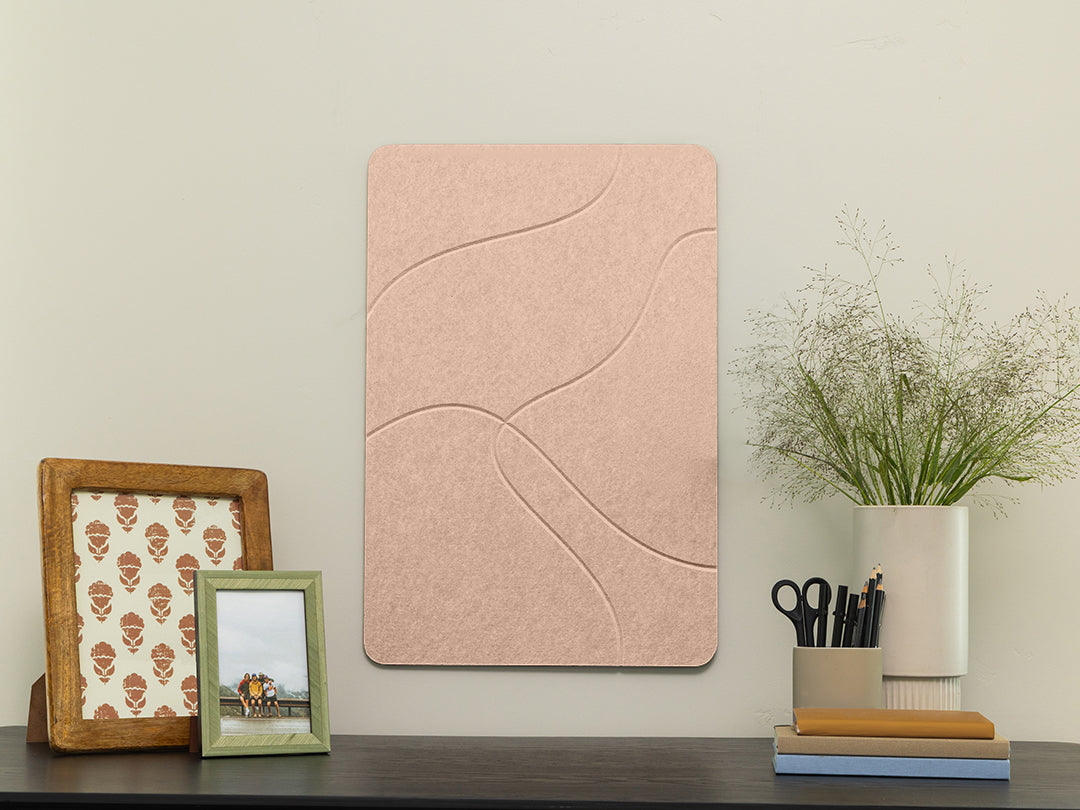 Pink textured wall panel on a wall with decorative items below