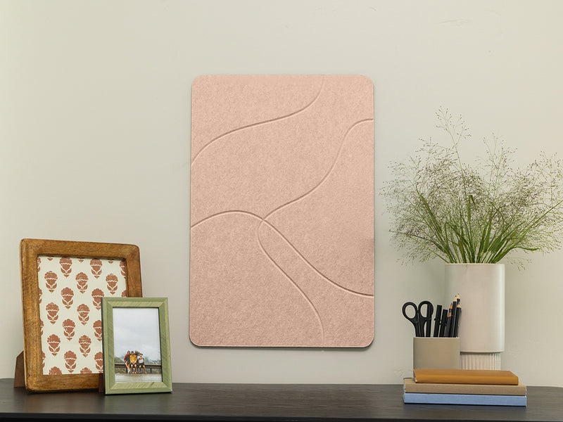 Pink textured wall panel on a wall with decorative items below