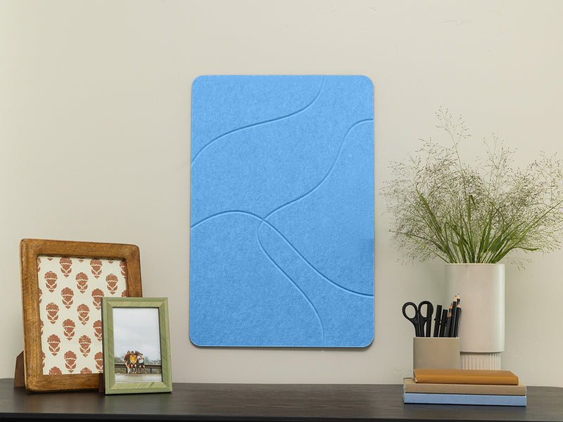 Blue acoustic panel on a wall with decorative items below