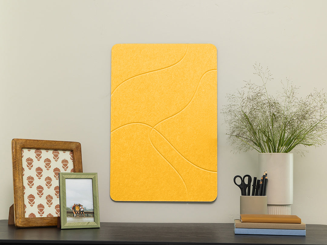 Yellow wall art piece on a wall with decorative items below