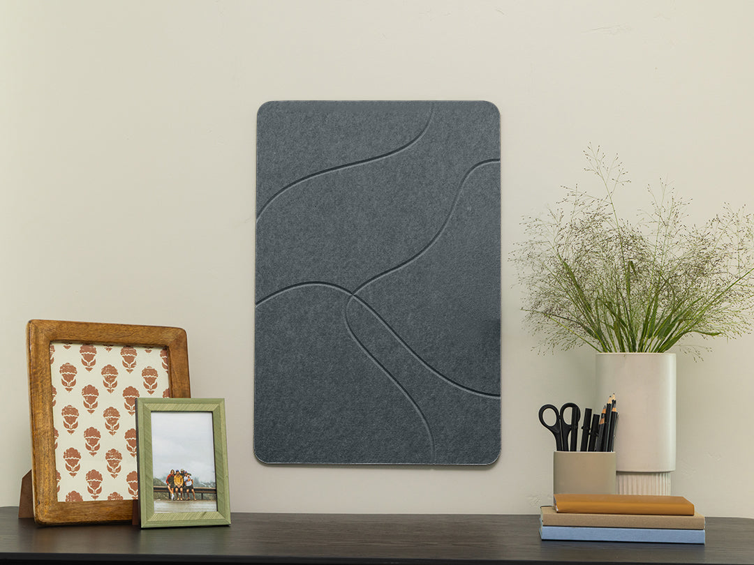 Dark gray acoustic panel on a wall with decorative items below