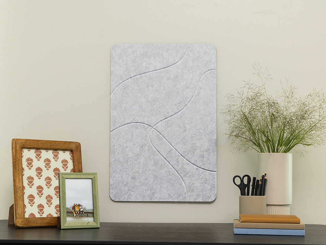 Decorative wall panel on a shelf with picture frames and a plant