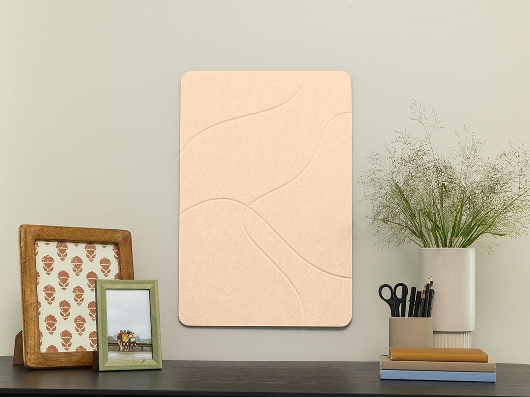 Decorative wall panel on a shelf with framed pictures and a vase.