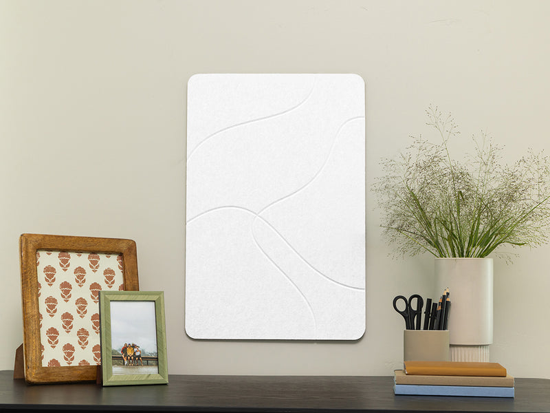 White rectangular mirror on a wooden surface with decorative items.