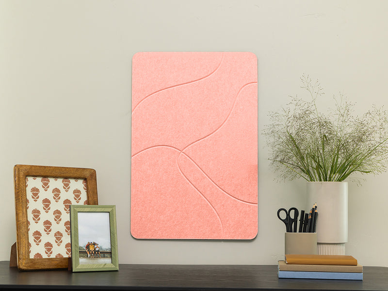 Pink wall art panel on a wall with decorative items below