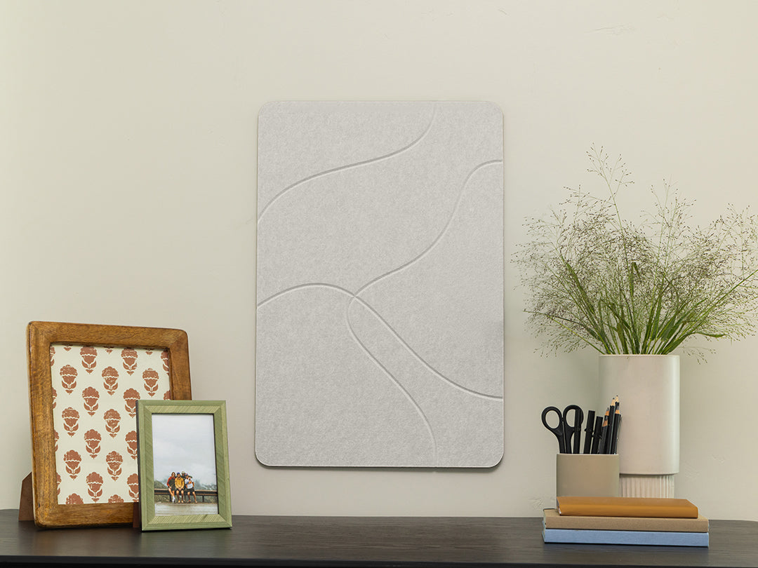 Decorative wall panel on a shelf with picture frames and a plant