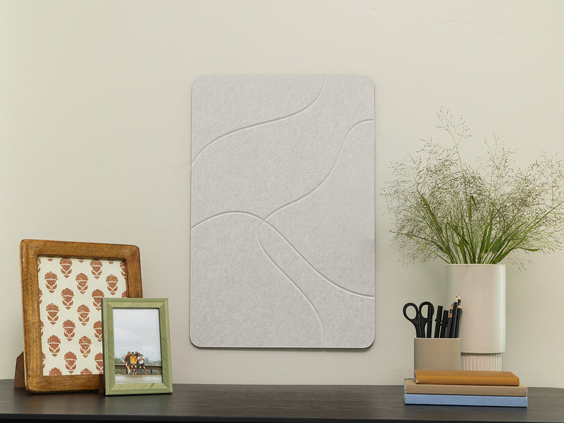 Decorative wall panel on a shelf with picture frames and a plant