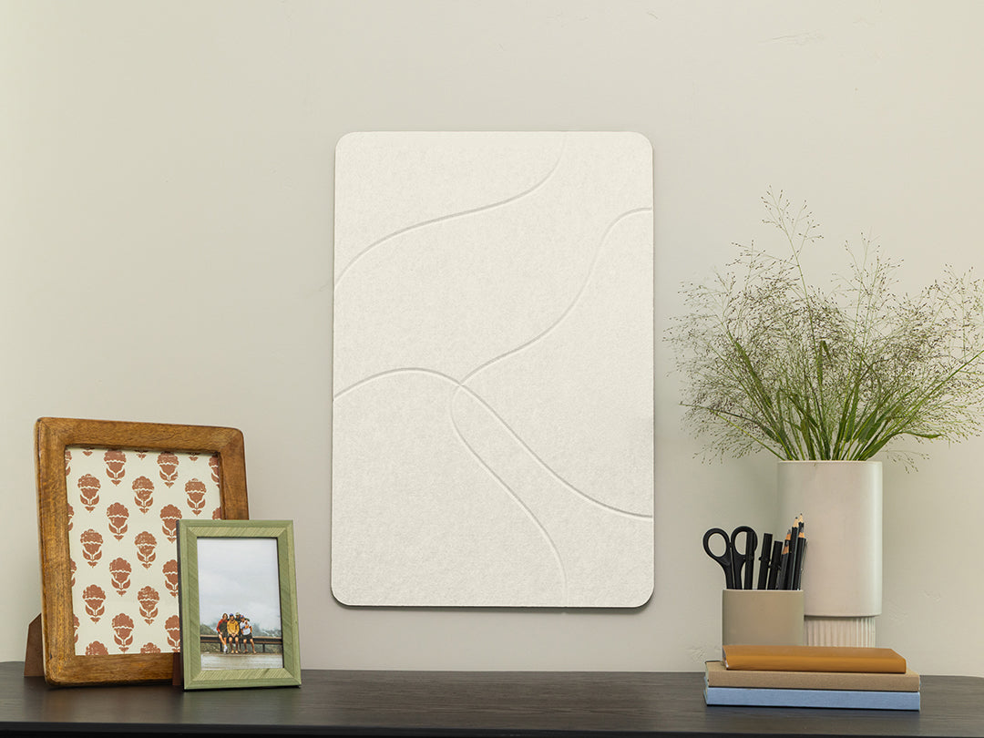 White textured wall art piece on a shelf with decorative items