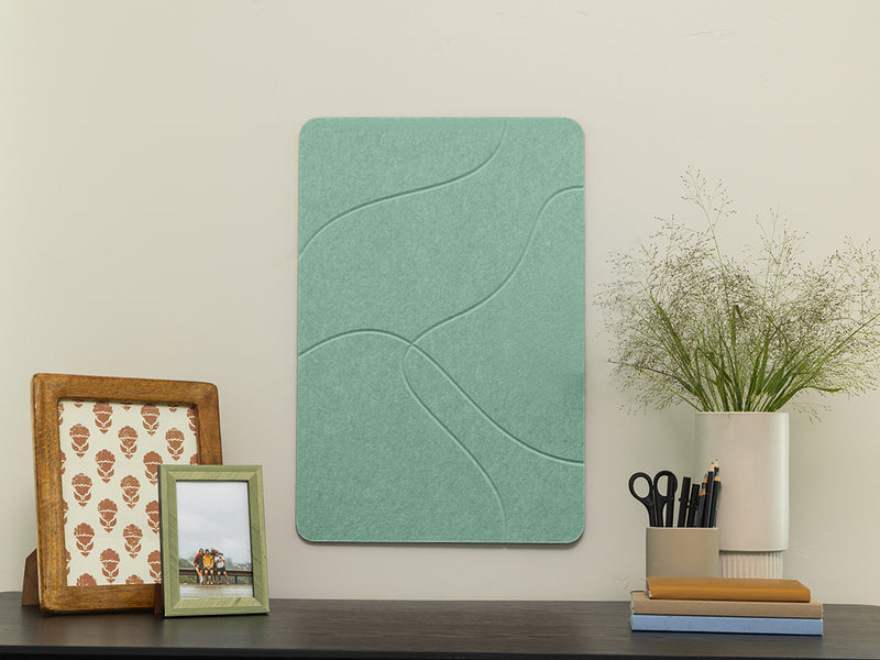 Decorative wall panel on a shelf with framed pictures and a vase.