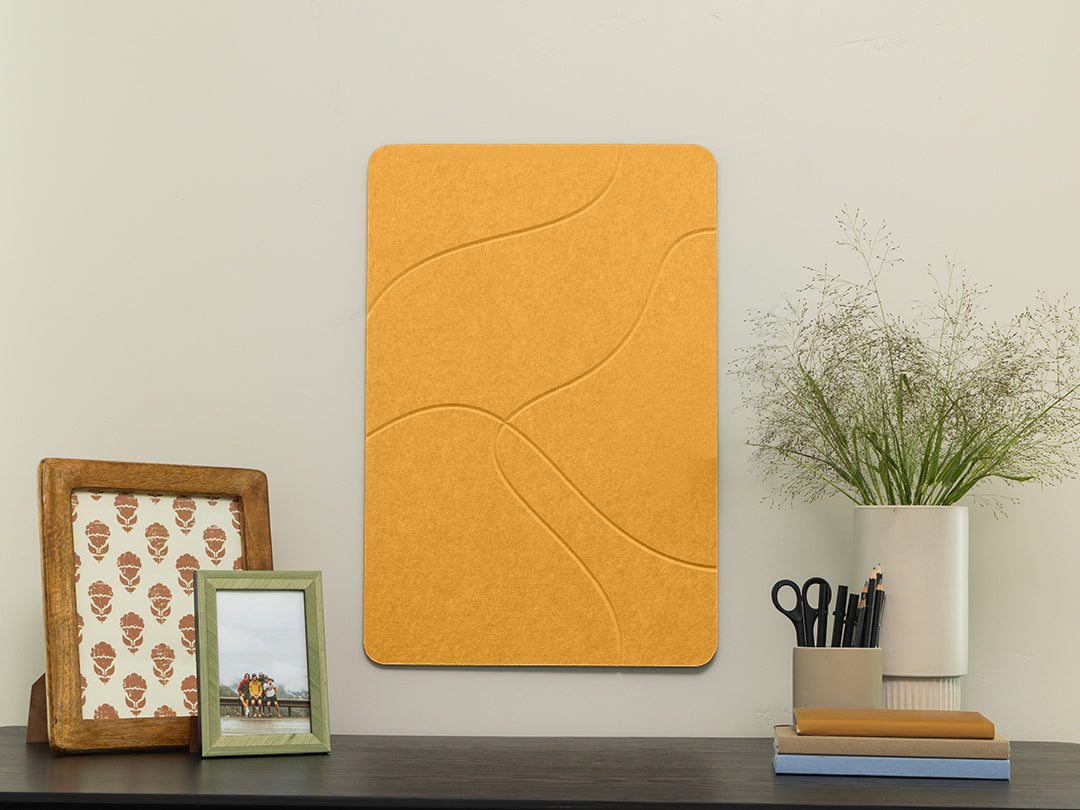 Yellow textured wall panel on a white wall with decorative items below.