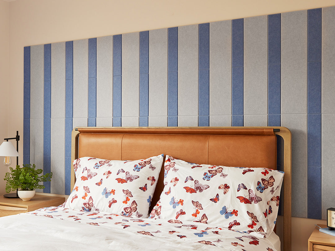 Felt Right wall art design using shades of blue felt tiles on a wall behind a headboard in a bedroom