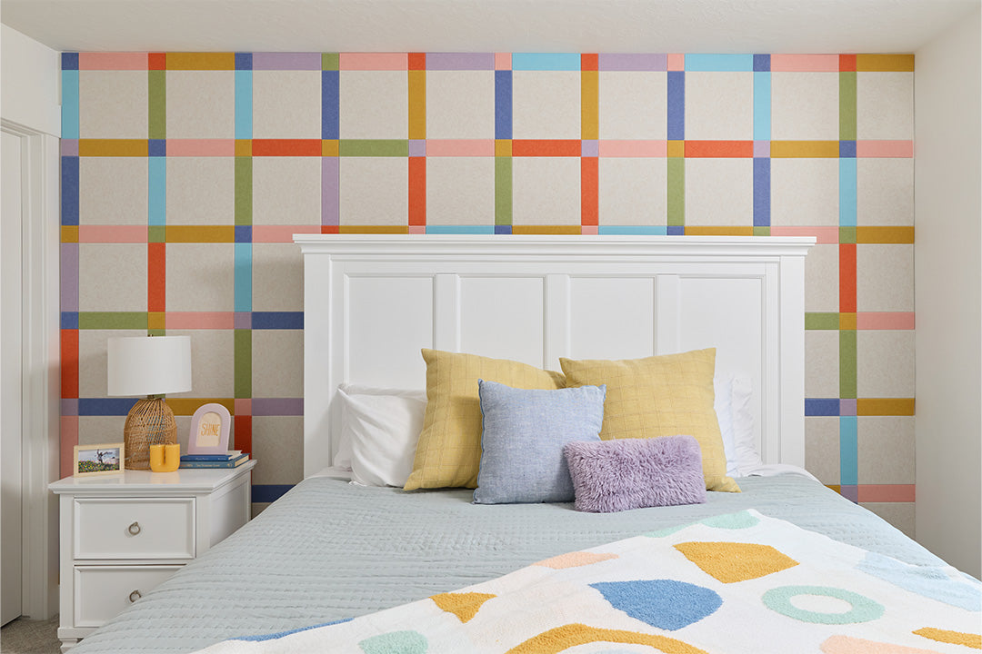 Felt Right plaid design on wall behind bed.