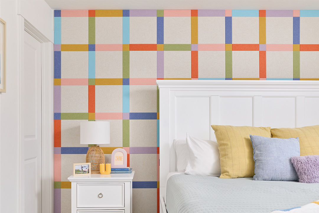 Felt Right plaid design on wall behind bed.