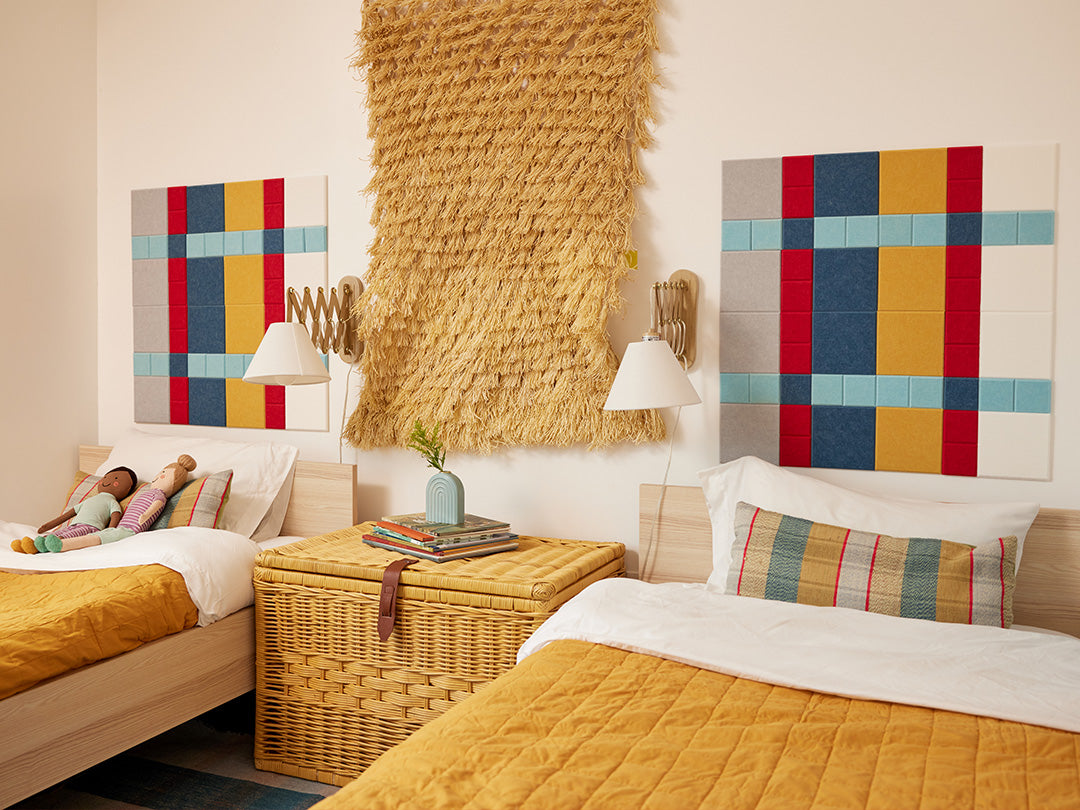 Felt Right plaid design using shades of blues, red, yellow, white, and grey felt square tiles in a kids room above the beds 