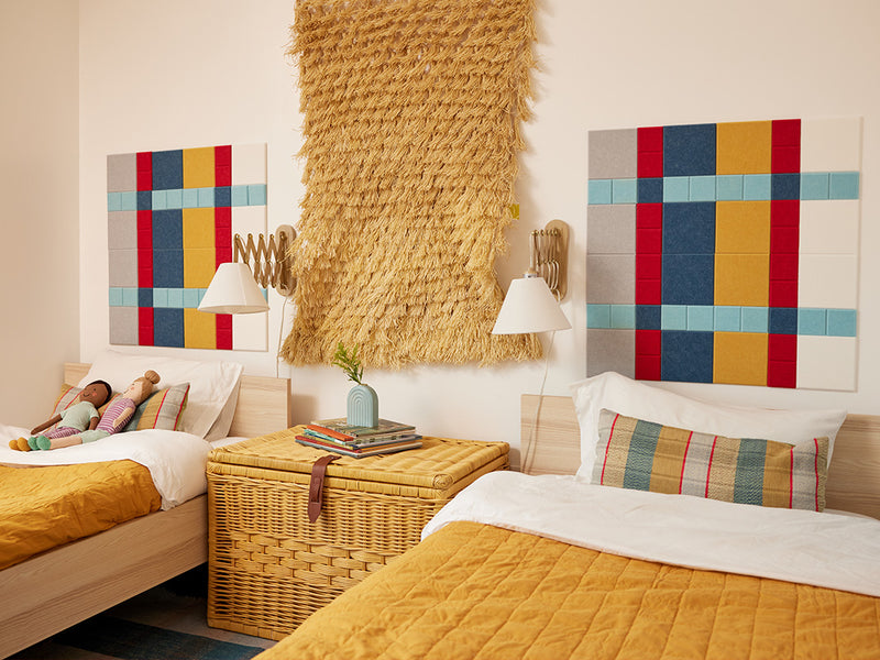 Felt Right plaid design using shades of blues, red, yellow, white, and grey felt square tiles in a kids room above the beds 