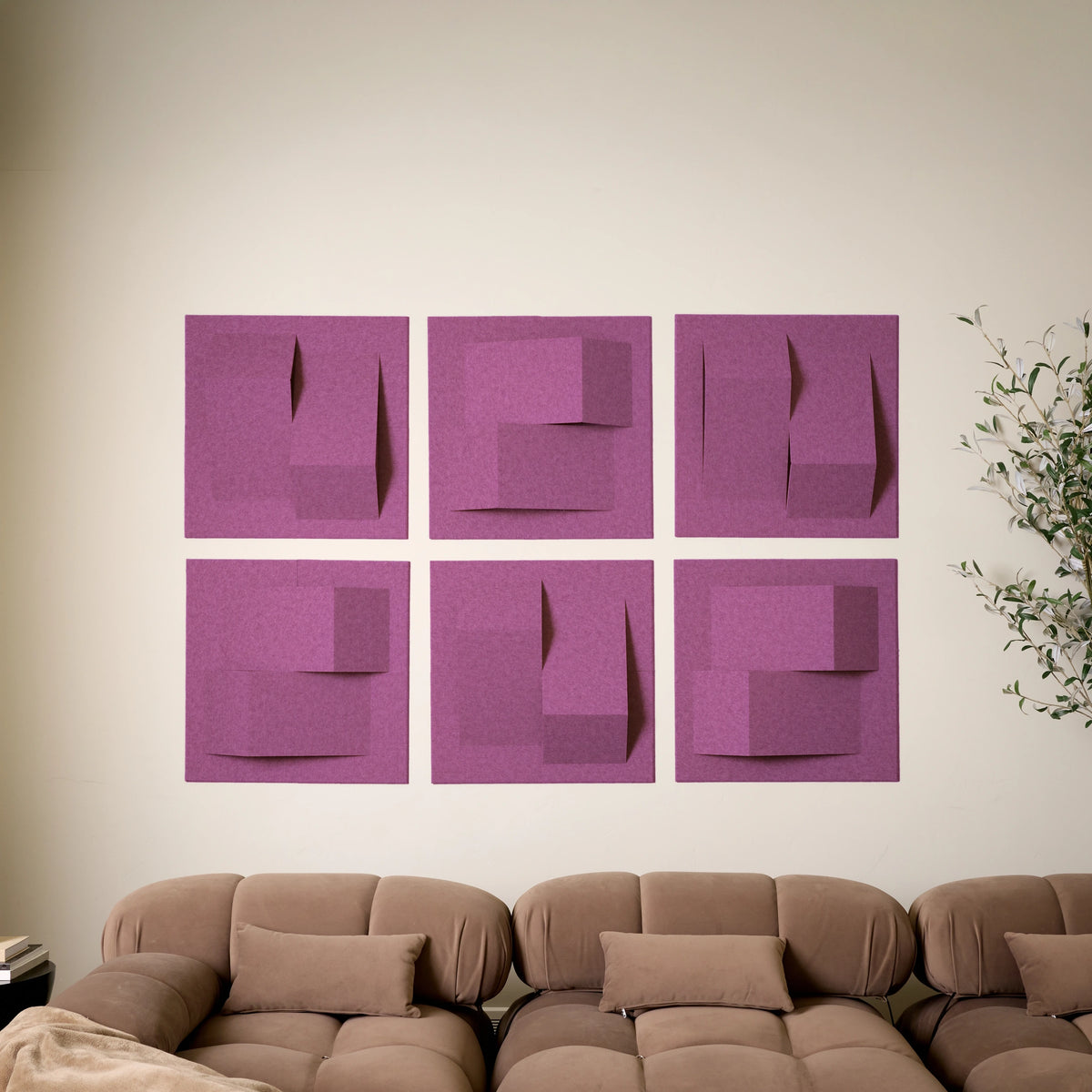 Purple-pink acoustic felt tiles in a modern 3D design above a couch