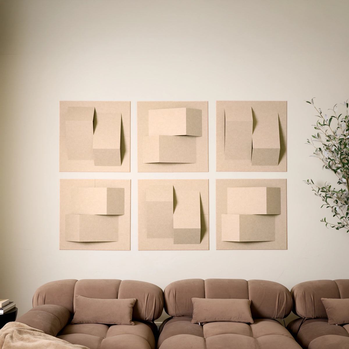 Light tan felt acoustic tiles with peak dimensions on a wall above a couch