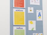 Weekly planner with daily tasks on a blue grid wall