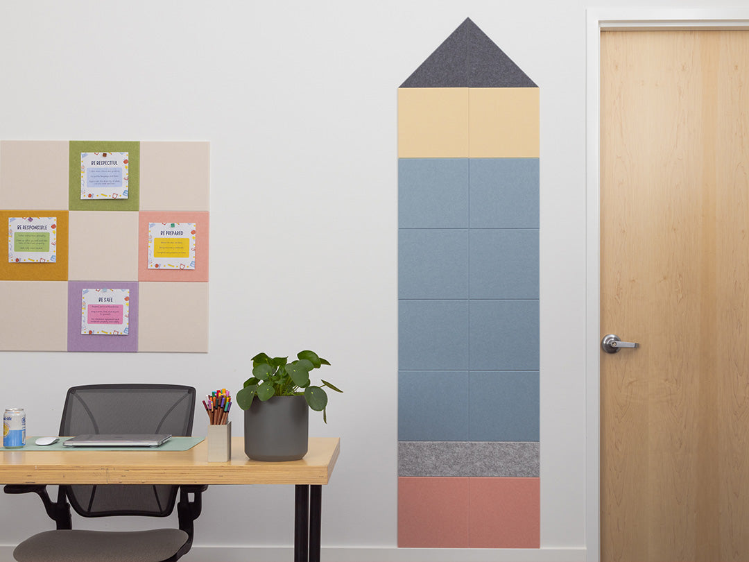 Colorful wall panels in a room with a desk and door.