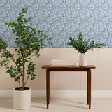 Blue-gray tile with delicate white floral and vine pattern displayed on wall above cream subway tiles.