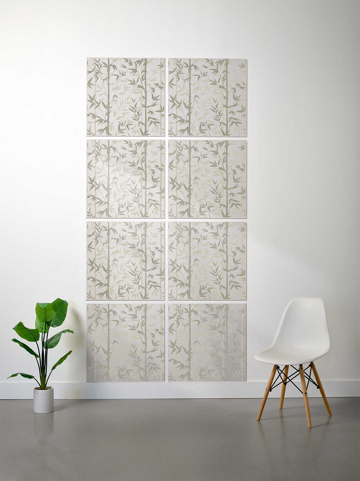 Wall with decorative panel featuring leaf patterns, a white chair, and a plant on a gray floor.