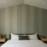 Beige tile with vertical dark pinstripes in repeating pattern, installed on bedroom wall.