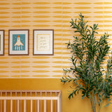 Tan and gold geometric patterned tile with repeating oval shapes displayed on nursery wall.