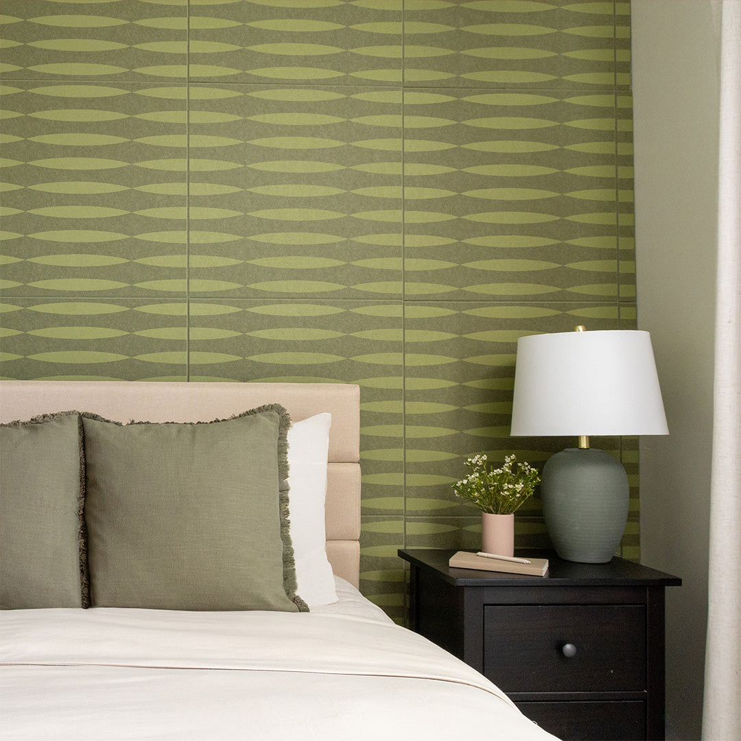 Green and tan striped wall tiles installed in a bedroom above a bed headboard.