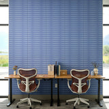 Blue tiles with horizontal stripe pattern covering wall behind office desk with two chairs.