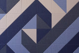 Geometric tile pattern with dark blue, light blue, and beige triangular sections creating a diamond motif.