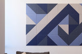 Blue and beige geometric wall tiles with triangular patterns in varying shades of navy, light blue, and gray.