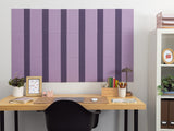 Purple bulletin board with alternating dark purple vertical pinstripes mounted above wooden desk.