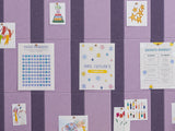 Purple and gray striped bulletin board with multiple white cards pinned across surface displaying educational charts and colo