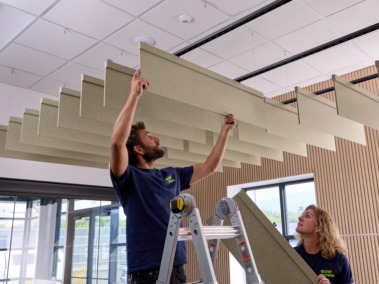 Two people installing colorful wall tiles